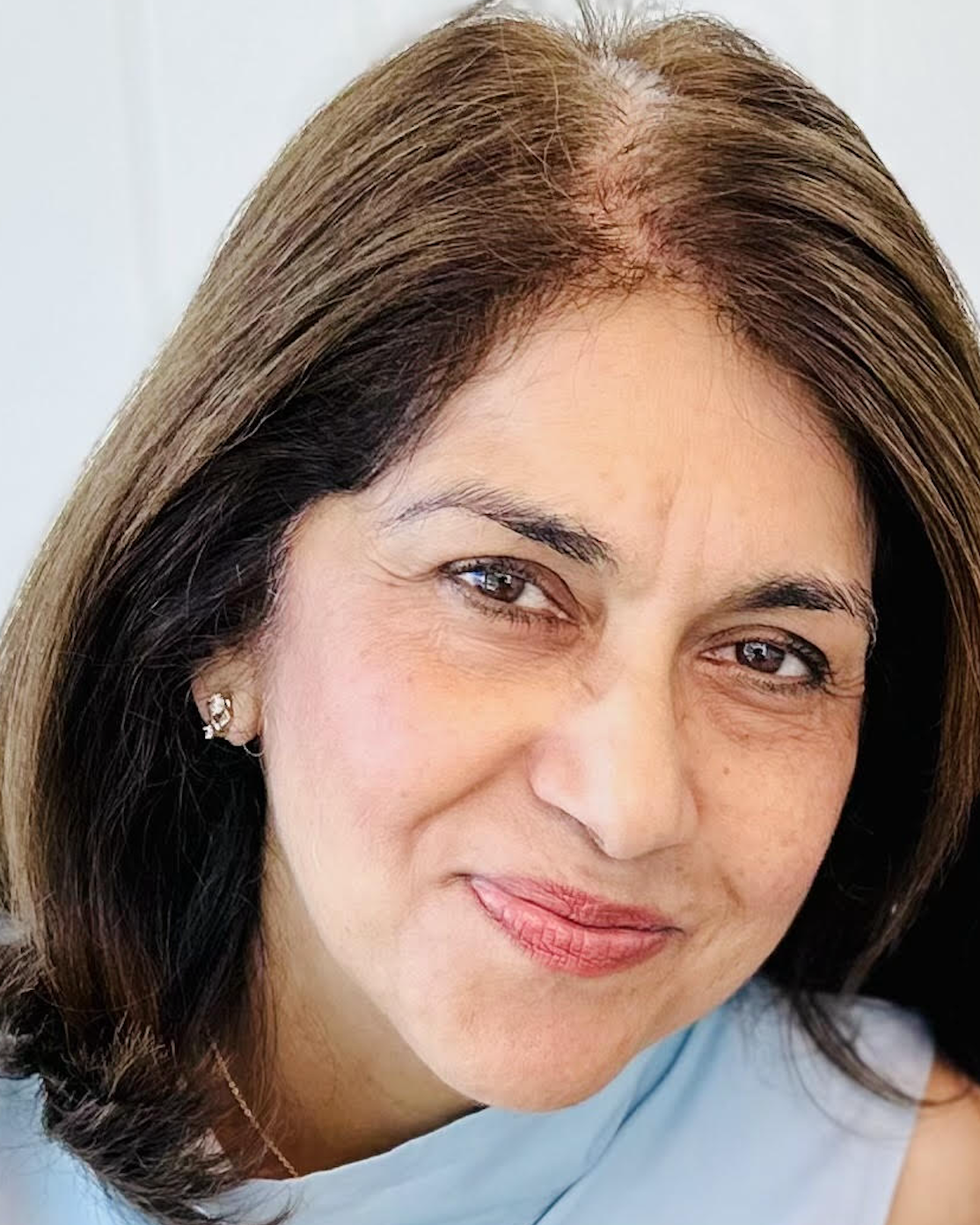 A photo of a South Asian woman wearing a light blue shirt.